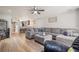 Open living room with wood floors, neutral paint, ceiling fan, and grey sectional sofa at 14910 Par Club Cir, Tampa, FL 33618