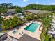 Aerial view of community pool and hot tub surrounded by palm trees and residential buildings at 14910 Par Club Cir, Tampa, FL 33618