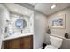Elegant powder room featuring a wood vanity, marble countertop, decorative mirror, and coastal accents at 1500 Sunset Rd # F8, Tarpon Springs, FL 34689