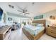 Spacious bedroom with a king-size bed, ceiling fan, views of the backyard, and a dedicated work area at 1500 Sunset Rd # F8, Tarpon Springs, FL 34689