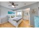 Bright bedroom featuring a ceiling fan, light walls, wood-look floors, coastal decor, and ample natural light at 1500 Sunset Rd # F8, Tarpon Springs, FL 34689