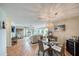Open-concept living room with dining area featuring a glass table, stylish decor, and access to outdoor space at 1500 Sunset Rd # F8, Tarpon Springs, FL 34689