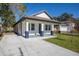 Stylish renovated home with a long driveway and manicured lawn, showcasing modern curb appeal at 1808 E Comanche Ave, Tampa, FL 33610