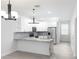 Modern kitchen featuring white cabinetry, stainless steel appliances, a breakfast bar, and designer lighting at 1808 E Comanche Ave, Tampa, FL 33610