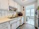 Bright kitchen with white cabinets and updated appliances overlooking a charming sitting room at 1847 Shore S Dr # 204, South Pasadena, FL 33707