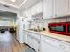 Galley-style kitchen with white cabinetry, stainless sink and view into the living area at 1847 Shore S Dr # 204, South Pasadena, FL 33707