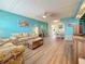 Open-concept living room featuring a floral sofa set, and views of the dining area and kitchen at 1847 Shore S Dr # 204, South Pasadena, FL 33707