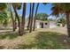 View of the backyard lined with mature trees and featuring a neutral colored exterior at 1923 W State St, Tampa, FL 33606
