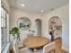 Charming dining area featuring a round table, wood floors, and arched entryway to the kitchen at 1923 W State St, Tampa, FL 33606