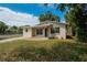Charming home featuring a well-manicured lawn, brick walkway, neutral paint, and mature landscaping at 1923 W State St, Tampa, FL 33606