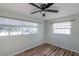 Bedroom with wood floors and ample natural light from two large windows with blinds at 2030 Magnolia Dr, Clearwater, FL 33764