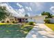 Charming single-story home featuring a brick facade, well-manicured lawn, and a two-car garage at 2030 Magnolia Dr, Clearwater, FL 33764