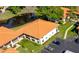An aerial view shows the building's orange tile roof with a pond and landscaping surrounding the complex at 2213 Hammock Pine Blvd, Clearwater, FL 33761