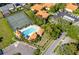 Aerial view featuring a refreshing community pool, tennis courts, and ample parking at 2213 Hammock Pine Blvd, Clearwater, FL 33761