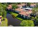 Aerial view of the complex with buildings, tile roofs, pond, landscaping and parking at 2213 Hammock Pine Blvd, Clearwater, FL 33761