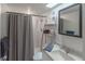 Functional bathroom with a shower, vanity, mirror, and storage shelves for essentials at 2213 Hammock Pine Blvd, Clearwater, FL 33761