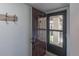 Entryway with a dark wooden door, rustic coat rack, and a glimpse of the outside through a glass screen door at 2213 Hammock Pine Blvd, Clearwater, FL 33761