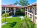 Inviting condo exterior with lush landscaping, red tile roof, and multiple floors of units at 2213 Hammock Pine Blvd, Clearwater, FL 33761