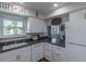 Bright kitchen with white cabinets, black countertops, a window, and essential appliances at 2213 Hammock Pine Blvd, Clearwater, FL 33761