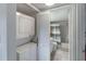 A stacked washer and dryer beside a full bath with a shower and tub at 2213 Hammock Pine Blvd, Clearwater, FL 33761