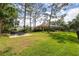 Expansive backyard featuring a patio with outdoor furniture and a lush, well-manicured lawn at 2220 Muirfield Way, Oldsmar, FL 34677
