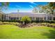 Beautiful backyard featuring a well-maintained lawn, privacy hedges, and a screened-in pool area at 2220 Muirfield Way, Oldsmar, FL 34677
