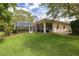 Expansive backyard featuring lush green lawn and screened-in patio, perfect for outdoor living and entertaining at 2220 Muirfield Way, Oldsmar, FL 34677