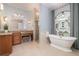 Bright bathroom showcasing a stylish soaking tub, granite vanity, and walk-in shower at 2220 Muirfield Way, Oldsmar, FL 34677