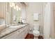 This bathroom offers bright vanity lighting, a granite countertop, and hardwood flooring at 2220 Muirfield Way, Oldsmar, FL 34677