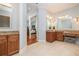 Well-lit bathroom featuring double vanities, granite countertops, and a large mirror with vanity seating at 2220 Muirfield Way, Oldsmar, FL 34677