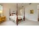 This primary bedroom features a four-poster bed, ceiling fan, and an ensuite bathroom at 2220 Muirfield Way, Oldsmar, FL 34677