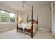 Inviting bedroom featuring a four-poster bed, plush carpet, and serene natural light at 2220 Muirfield Way, Oldsmar, FL 34677