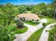 Stunning aerial view of a luxurious home featuring a circular driveway and lush landscaping at 2220 Muirfield Way, Oldsmar, FL 34677