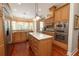 Modern kitchen featuring custom cabinetry, stainless steel appliances, and a center island at 2220 Muirfield Way, Oldsmar, FL 34677