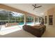 This screened-in lanai features a seating area, views of the pool and lush landscaping at 2220 Muirfield Way, Oldsmar, FL 34677