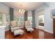 Elegant living room featuring striped chairs, ottomans, wood floors, and ample natural light from large windows at 2220 Muirfield Way, Oldsmar, FL 34677