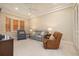 Comfortable living room with neutral carpet, tray ceiling, cozy seating, and large bright windows at 2220 Muirfield Way, Oldsmar, FL 34677