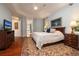 Spacious main bedroom features tray ceiling, wood floors, and view to large soaker tub in ensuite at 2220 Muirfield Way, Oldsmar, FL 34677