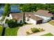 Aerial view of a waterfront property featuring beautiful landscaping, a circular driveway, and a well-maintained exterior at 2347 Foggy Ridge Pkwy, Land O Lakes, FL 34639
