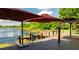 Stunning backyard deck with lake view, featuring a pier, pergola, and patio umbrella for lakeside relaxation at 2347 Foggy Ridge Pkwy, Land O Lakes, FL 34639