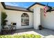 Close up of a well-kept front entrance featuring an arched window and tasteful landscaping at 2347 Foggy Ridge Pkwy, Land O Lakes, FL 34639