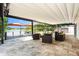 Travertine tiled outdoor space features retractable awning and seating overlooking waterfront deck at 2347 Foggy Ridge Pkwy, Land O Lakes, FL 34639