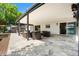 Covered outdoor patio with travertine tile, black wicker furniture and access to the home at 2347 Foggy Ridge Pkwy, Land O Lakes, FL 34639