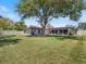 Spacious backyard with lush lawn, mature tree, and a screened porch at 2673 Clubhouse S Dr, Clearwater, FL 33761
