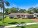 Charming single-story home boasting well-manicured lawn, lush landscaping and inviting brick walkway at 2673 Clubhouse S Dr, Clearwater, FL 33761