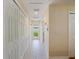 Bright hallway with tiled floor and ample closet space leading to the home's back door at 2673 Clubhouse S Dr, Clearwater, FL 33761