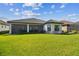 Expansive backyard with lush green lawn, enclosed porch, and manicured landscaping at 29356 Ginnetto Dr, Wesley Chapel, FL 33543