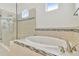 Bright bathroom featuring a glass-enclosed shower and a soaking tub with tile surround at 29356 Ginnetto Dr, Wesley Chapel, FL 33543