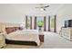 Spacious bedroom with soft carpet, tray ceiling, curtains, and plenty of natural light at 29356 Ginnetto Dr, Wesley Chapel, FL 33543