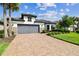 Charming single-story home featuring a gray garage door, tile roof, and a well-manicured lawn at 29356 Ginnetto Dr, Wesley Chapel, FL 33543